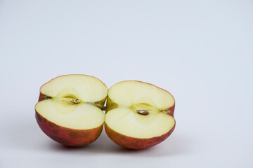 Red apple cut in half. Two pieces of fruit.