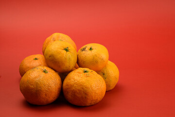 Orange tangerines close-up isolated on red background