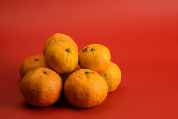 Orange tangerines close-up isolated on red background