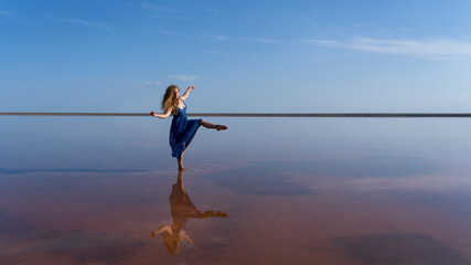 beautiful curly-haired, cheerful girl playfully walks along the seashore enjoys life, freedom of action, emotion