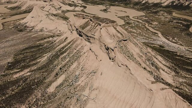 Aereal wide view with circular movement arround big mountain of the desert landscape in Bardenas Reales, Navarra, Spain, Europe.