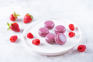 Berries macarons with cream filling and fresh strawberries and raspberries