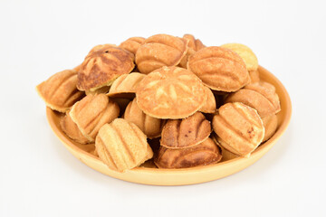 Walnut shell cookies lined with slide on wooden plate and isolated on white background