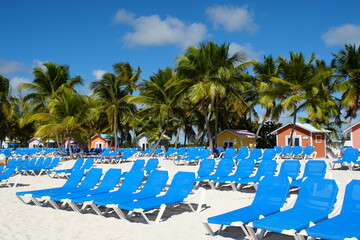 The empty beach chairs in front of colorful bungalows on the island of Princess Cays, Bahamas © Khairil