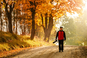 Obraz premium Beautiful colourful autumn sunrise and a male photographer in distance.