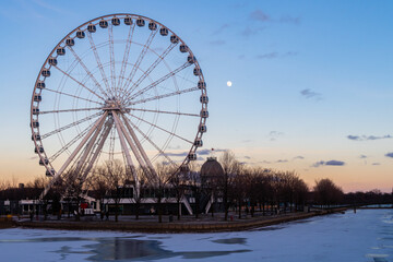 Montreal, Canada - May 2020 : Ferris wheel in the old port with the full moon in the background