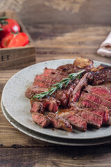 grilled red beef pork meat barbecue steak fillet with rosemary sprig and hot sauce served on plate