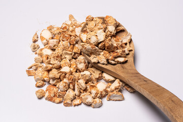 Sand ginger, latin name Kaempferia galanga dried roots heap with a wooden spoon close-up view on white background