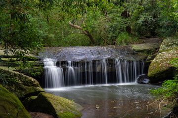 Fototapeta na wymiar Small waterfall along Terry's creek, Epping, Australia.