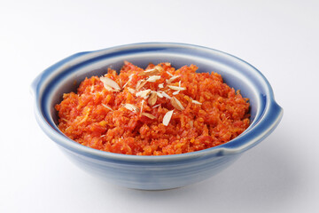 Fototapeta na wymiar Gajar ka halwa is a carrot-based sweet dessert pudding from India. Garnished with Cashew/almond nuts and Served in a bowl