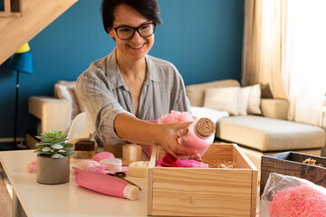 Young woman packing gift box set of natural spa kit, bath amenities for Mother's and Valentines Day