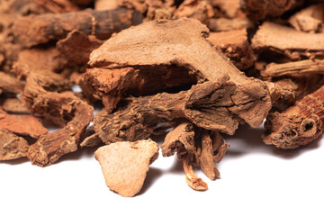 Lesser galangal, latin name Alpinia officinarum dried roots heap close-up view on white background