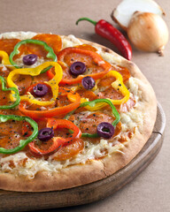 Italian pizza in wood plate on the table and garlic  and peppers