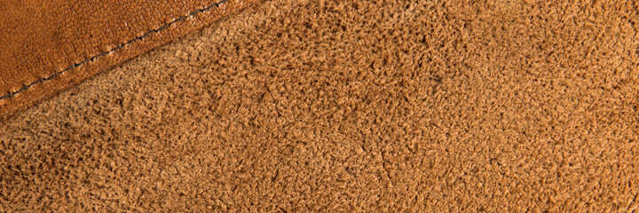 leather grunge background: an old piece of tough camel skin, with scuffs, spots, scars, stitched...