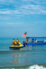 Boat pulling floating water raft and banana boat in the sea.