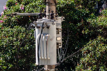 Electric power transformer on a public lighting pole on street in Brazil