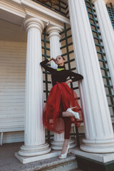Girl in a red tutu in a city garden