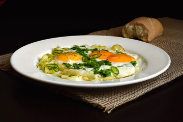 fried eggs on stewed leeks and herbs hot peppers
