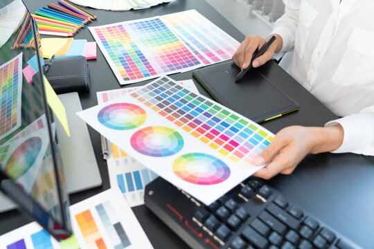 interior designer or creative graphic designer working on project architectural with colour samples with work tools and equipment for selection in office