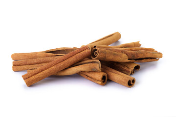 Heap of cinnamon sticks on white