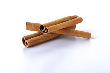 Heap of cinnamon sticks on white