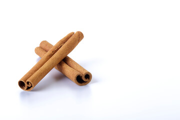 Heap of cinnamon sticks on white