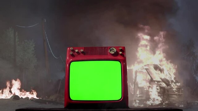 Vintage Television with Green Screen on a Street with a Burning Van in the Background. Dolly In. You can replace green screen with the footage or picture you want with &ldquo;Keying&rdquo; effect in AE. 4K.