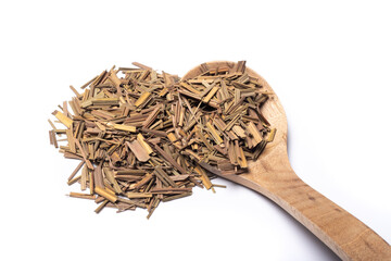 Organic dried lemongrass, latin name cymbopogon citratus heap with a wooden spoon on white background