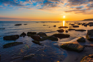 Colorful bright sunrise on rocky sea coast