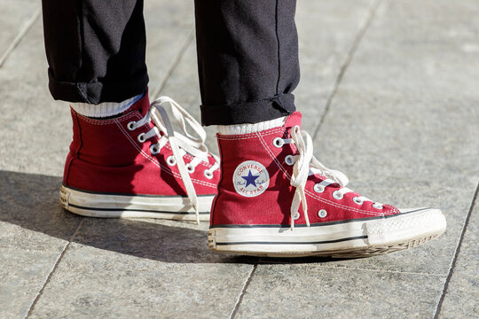Lviv, Ukraine - December 27, 2020. Person wearing red pair of Converse Chuck Taylor All Stars on the street.