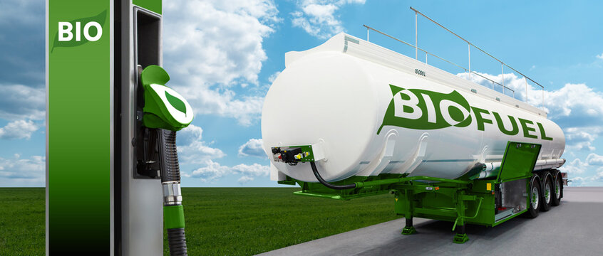 Tank trailer with biofuel and filling station on the background of a green field and blue sky