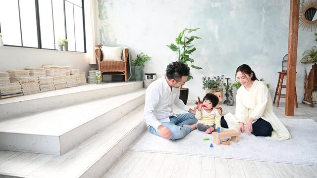 新築の様な白くて広い部屋で家族団らんの幸せな若いファミリーの動画　パン コピースペースあり