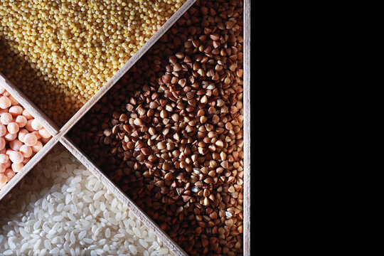 A set of grain cereals. Rice, buckwheat and millet groats in a wooden tray. A grocery set of cereals. Import of grain. © alexkich