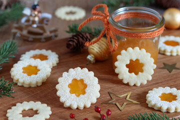 Fototapeta na wymiar Weihnachtsplätzchen Spitzbuben mit Aprikosenmarmelade auf Holzbrett