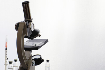 Research laboratory. Test tubes and microscope on the table on a white background.