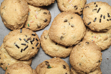 Many handmade chocolate cookies on a grey background