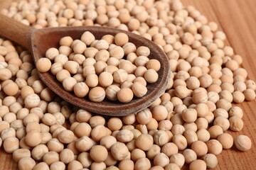Whole yellow peas in wooden spoon