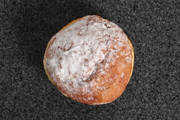 Fototapeta premium Doughnut without a hole filled with jam with sugar on top