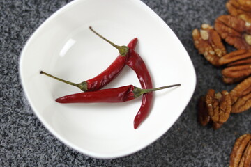 Chili pepper in bowl and pecan nuts