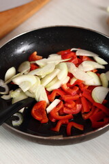 Frying pan with sliced onion and red bell pepper. Making Chicken and Egg Galette Series.