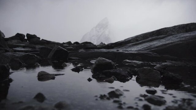 Reflejo en costa de rocas negras en Noruega
