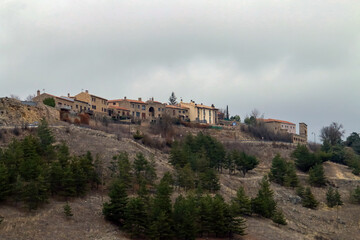 Fototapeta premium El pueblo viejo de Medinaceli situado sobre una colina y junto al castillo. La vieja villa de Medinaceli se sitúa por encima del pueblo nuevo desarrollado entorno a la estación de tren y la autopista.