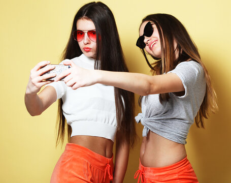 people, friends, teens and friendship concept - happy smiling pretty teenage girls taking selfie