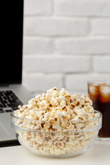Watching movie on laptop with popcorn and iced soda drink