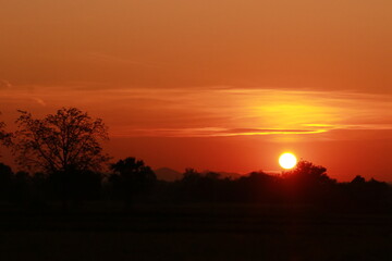 Fototapeta na wymiar Orange light of sunrise, silhouette and blue sky in the morning 