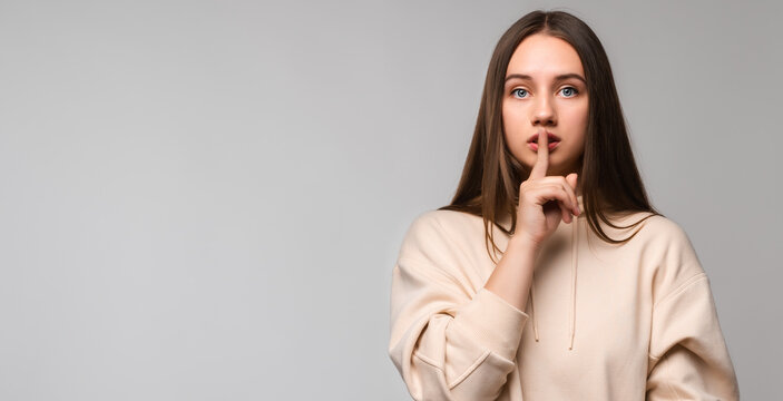 Image of Young beautiful brunette woman showing silence. Copy space