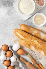 Baguette round bread. French baguette bread is surrounded by baking ingredients. Bread close-up....
