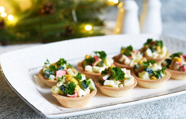 Tartlets with crab sticks and corn and champagne in a glass on the New Year's table.