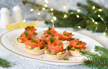 Avocado and salmon appetizer on the New Year's table. Tartlets with fish.