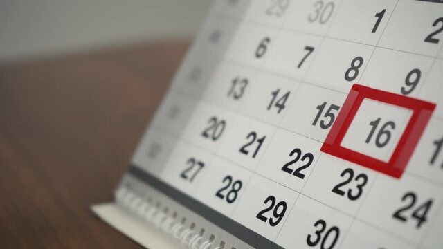 man changes the date on the calendar to the next day